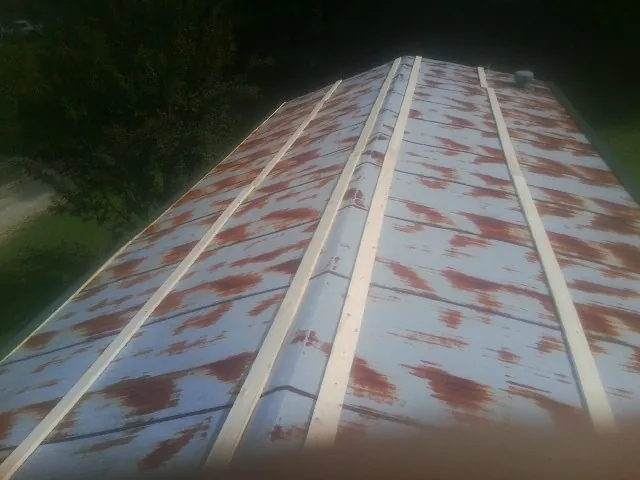 Rusted metal roof panels with new wood purlins before replacement — Storm Damage Roof Repair in Artemas by Roofing Brothers