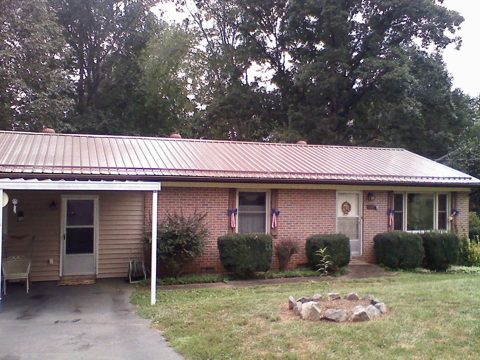 Bronze metal roof and carport on a brick ranch home — Roof Repair work by our crew in Artemas